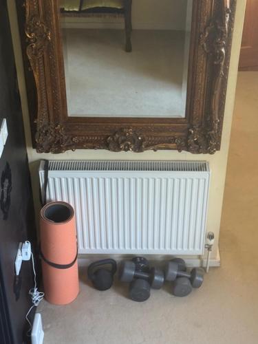 a mirror on a wall next to a radiator at Villa 10 min bus to Oxford train in Oxford