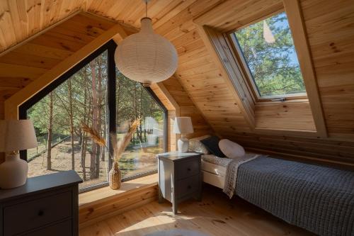 a bedroom with a large window in a log cabin at Polna Osada Nadkole in Nadkole