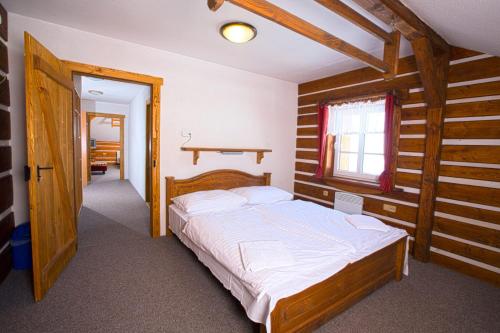 a bedroom with a large bed with a wooden frame at Horsky hotel Stumpovka in Rokytnice nad Jizerou