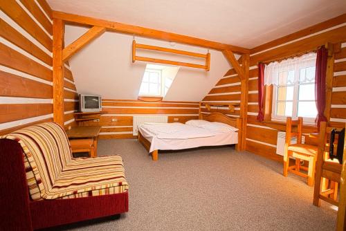 a bedroom with a bed and a chair in a room at Horsky hotel Stumpovka in Rokytnice nad Jizerou