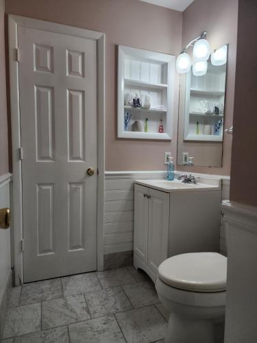 a bathroom with a toilet and a sink and a mirror at Tranquilidad y todo cerca in Matthews