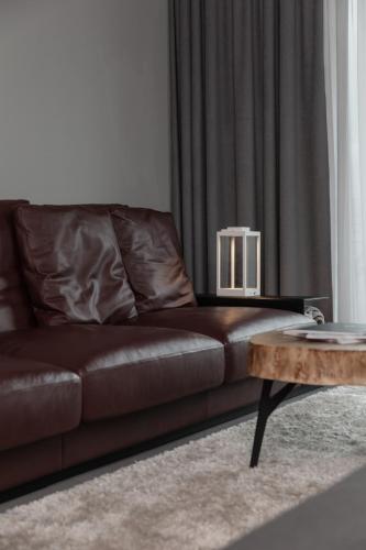 a brown leather couch in a living room with a coffee table at GOING TRIPLE A apartments WEST in Going