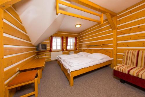 a bedroom with a bed in a wooden cabin at Horsky hotel Stumpovka in Rokytnice nad Jizerou