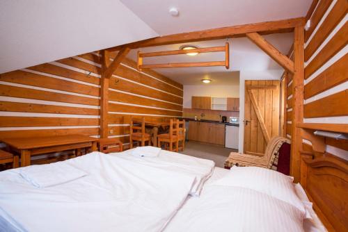 a bedroom with a bed and a table and a kitchen at Horsky hotel Stumpovka in Rokytnice nad Jizerou