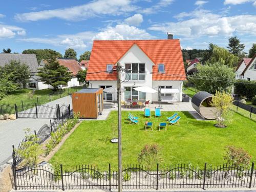 a house with an orange roof with a yard at Ferienhaus DeRuhHus in Rankwitz
