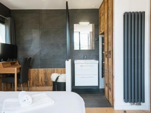 1 dormitorio con cama, lavabo y escritorio en Lodge 4****, 8 voyageurs, Sauna, Balcon, Accès internet, Parking - FR-1-304-217, en La Clusaz