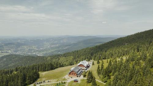 a house on the side of a hill with trees at Horsky hotel Stumpovka in Rokytnice nad Jizerou