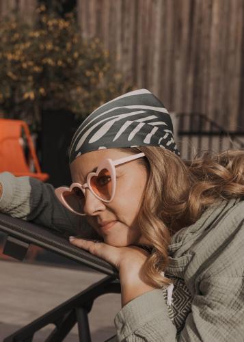 a woman wearing sunglasses and a hat and glasses at GOING TRIPLE A apartments WEST in Going