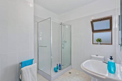 a white bathroom with a shower and a sink at Villa Curva do Monte by Villa Plus in Carvoeiro