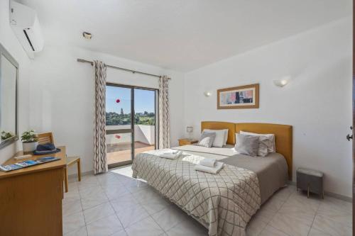 a bedroom with a bed and a large window at Villa Curva do Monte by Villa Plus in Carvoeiro