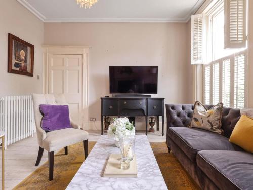 a living room with a couch and a tv at Prep House in Cheltenham