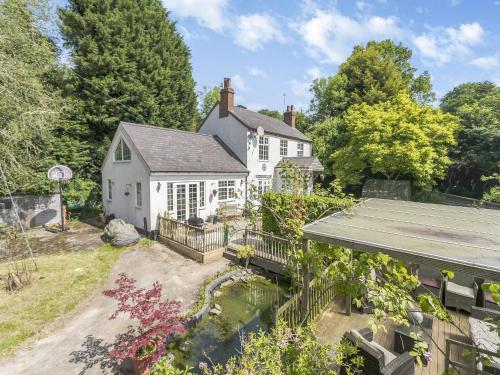 an exterior view of a white house with a yard at Oakdale Lodge in Hopwood