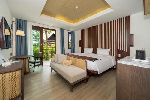 a bedroom with a bed and a couch and a desk at Howard Johnson by Wyndham Phuket Naiyang in Thalang