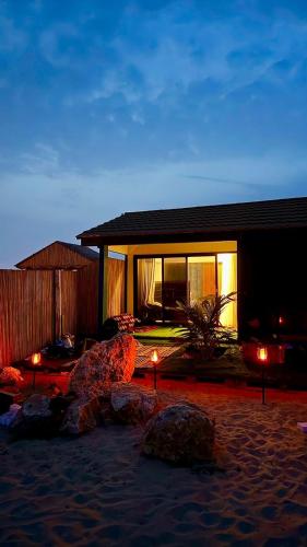 a house with lights in front of it at night at أكواخ الأصاله 