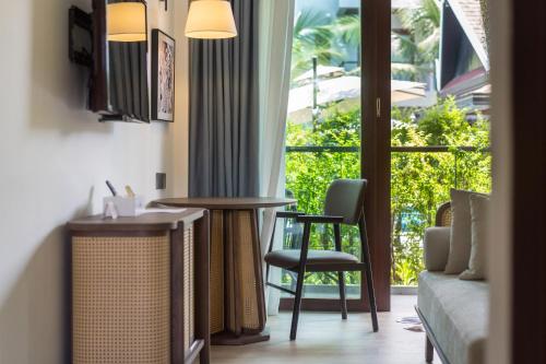 a room with a table and chairs and a window at Howard Johnson by Wyndham Phuket Naiyang in Thalang