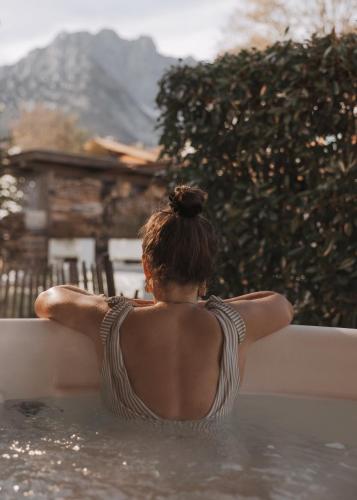 a woman sitting in a bath tub in the water at GOING TRIPLE A apartments WEST in Going