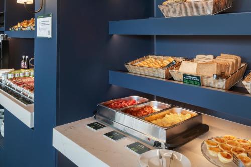 a buffet with many different types of pastries and bread at B&B HOTEL Setúbal Bonfim in Setúbal