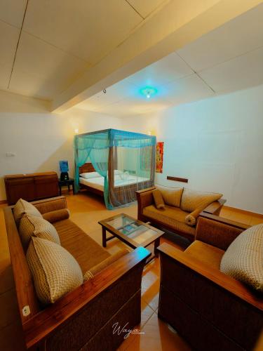 a living room with couches and a bed at Kalawathi Retreat Inn in Ratnapura