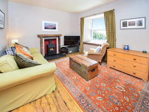 a living room with a couch and a fireplace at Hollin Bank Barn in Coniston