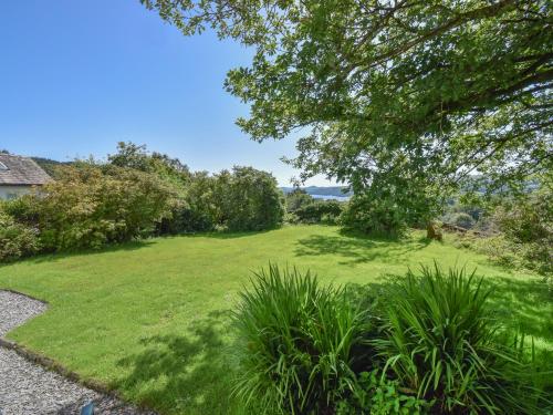a yard with a large lawn with trees at Hollin Bank Barn in Coniston