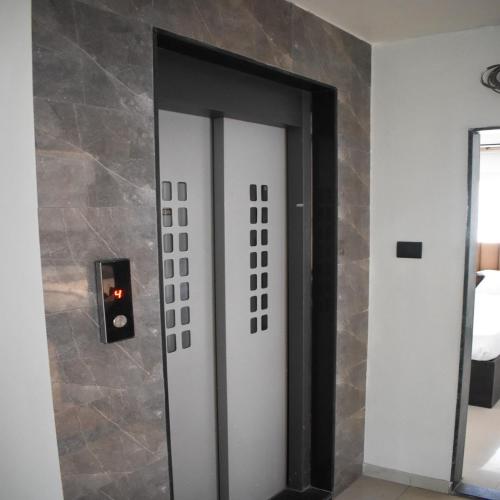 a door in a room with a stone wall at Lotus Excutive in Pune