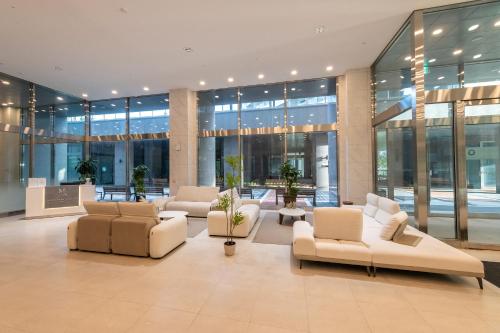 a lobby with couches and chairs in a building at 모어댄 속초해변점 in Sokcho
