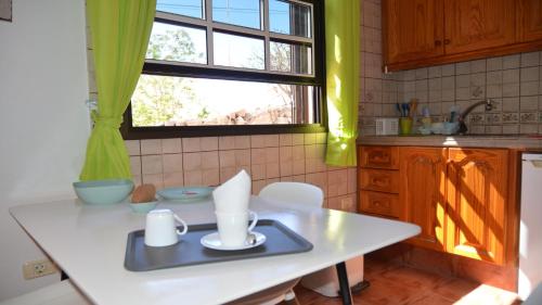cocina con mesa blanca y ventana en La Lonja 2, en Valle Gran Rey