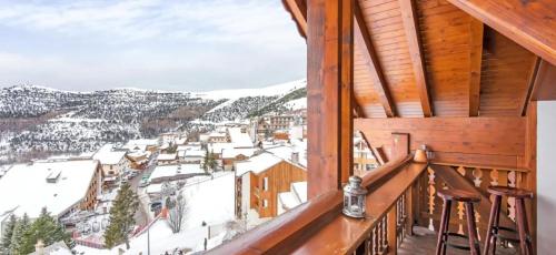 a balcony with a view of a town in the snow at Hotel Belle Étoile in LʼHuez