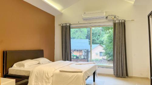 Un pat sau paturi într-o cameră la Jungle Resort Dandeli
