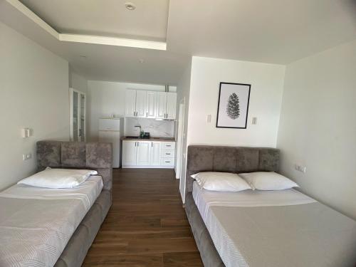 a room with two beds and a kitchen at Villa Scorpio in Qeparo