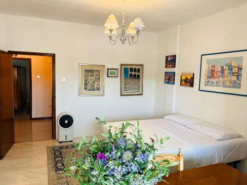 a bedroom with a bed and flowers on a table at Luxury Relax Apartment near Venice Station in Venice
