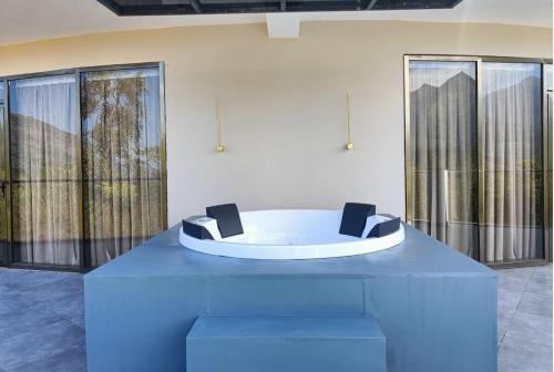 a blue table with two chairs in a room with large windows at Hotel Sky Sierra Wayanad in Kalpetta