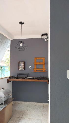 a room with a blue wall with a wooden desk at Apart 2 Ilha dos Araujos Rua 38 in Governador Valadares