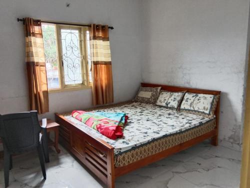 a bed in a room with a window at Vanilla homestay in Vālpārai