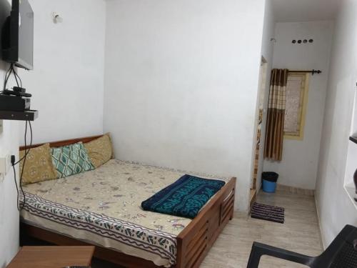 a small bedroom with a bed in a room at Vanilla homestay in Vālpārai