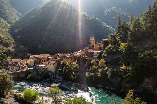 a small town on a mountain with a river at Casa Micino grazioso bilocale nel centro storico di Badalucco in Badalucco
