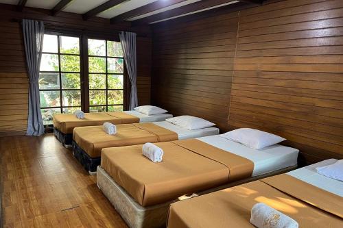 a row of beds in a room with wooden walls at Santa Monica Resort in Ciherangsating