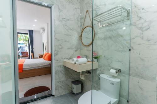 a bathroom with a shower and a toilet and a sink at Sunny Beach Villa in Danang