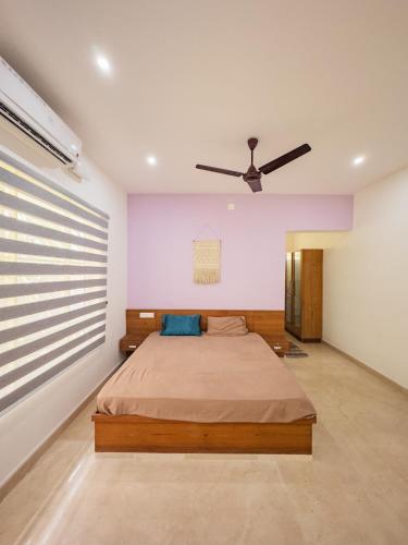 a bedroom with a bed and a ceiling fan at Akshaya Homestay in Trichūr