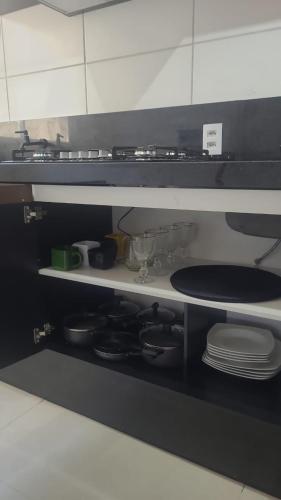 a kitchen with a stove and some plates and dishes at Canto da Mantiqueira - Staffy House Extrema in Extrema