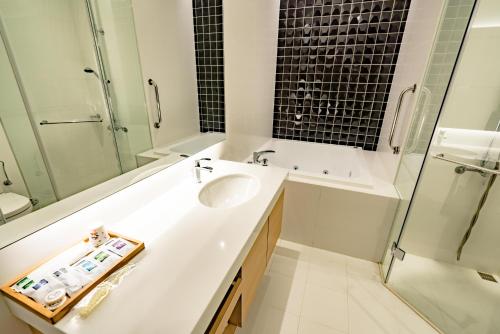 a white bathroom with a sink and a shower at Eusta Motel in Taichung