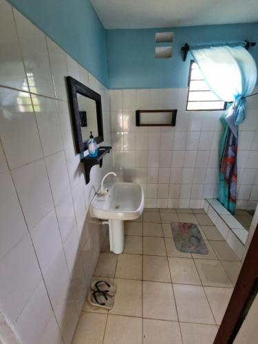 a bathroom with a sink and a mirror at Diani Beach Walk in Diani Beach