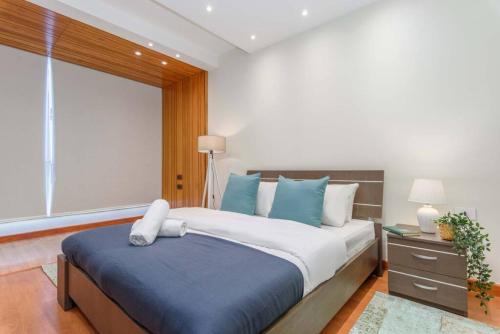 a bedroom with a large bed with blue and white pillows at Kali - Charming 2-BR Apt & Balcony in Antelias in Anţilyās
