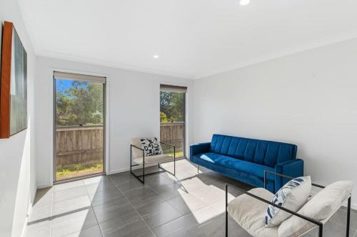 a living room with a blue couch and chairs at Grand and Serene Family Stay with Alfresco Living in Doolandella