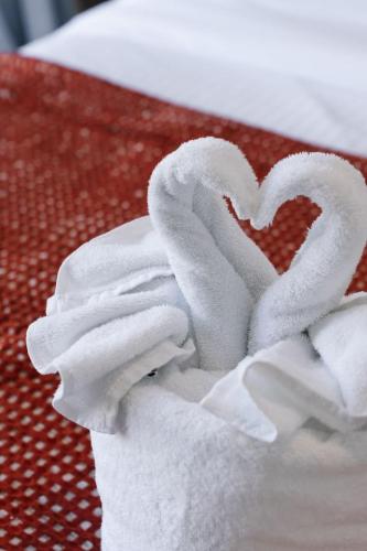 a pile of towels with a heart on a table at Grand and Serene Family Stay with Alfresco Living in Doolandella