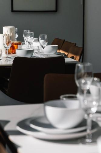 a table with plates and wine glasses on it at Grand and Serene Family Stay with Alfresco Living in Doolandella
