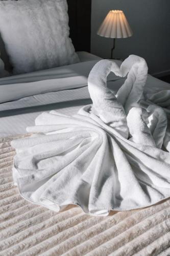 a white blanket on top of a bed at Grand and Serene Family Stay with Alfresco Living in Doolandella