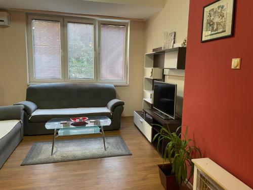 a living room with a couch and a tv at VEZO Apartment in Skopje