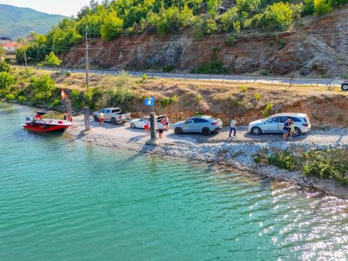 a group of cars parked on the side of a river at Bujtina Adora in Ara të Lumit