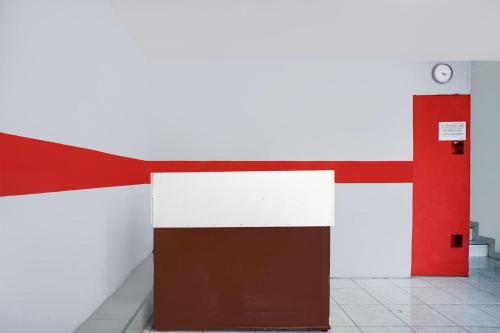 a room with a red and white wall and a door at Hotel O Medan near Universitas Sumatera Utara formerly Surya Residence 2 in Medan